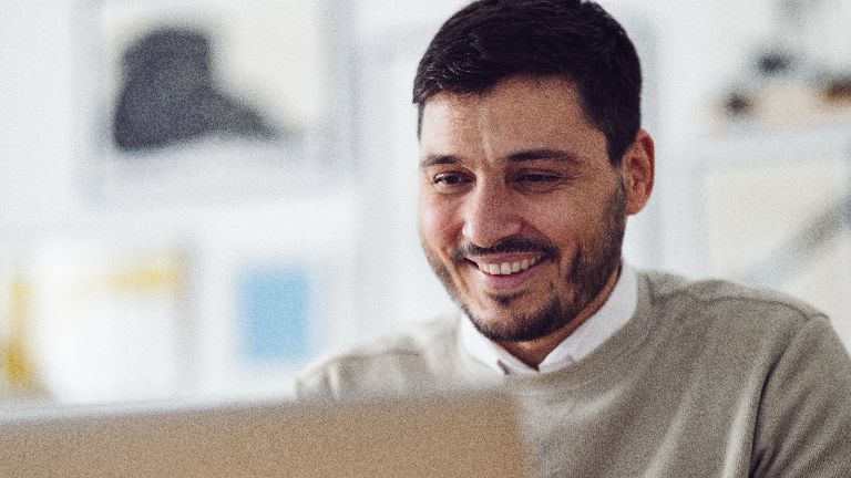 Mann blickt auf sein Notebook